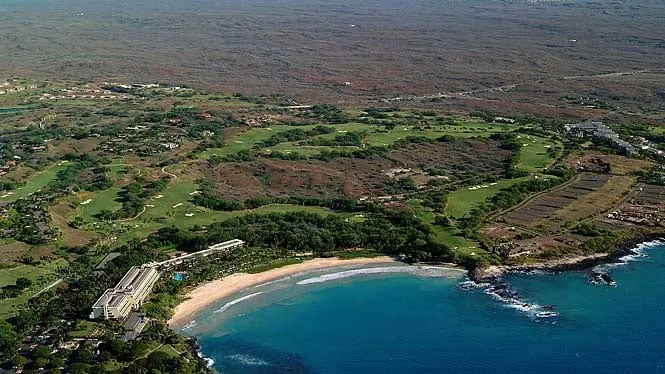 Aerial view of the crescent of Kaunaoa (Mauna Kea) Beach with the resort and golf course behind.