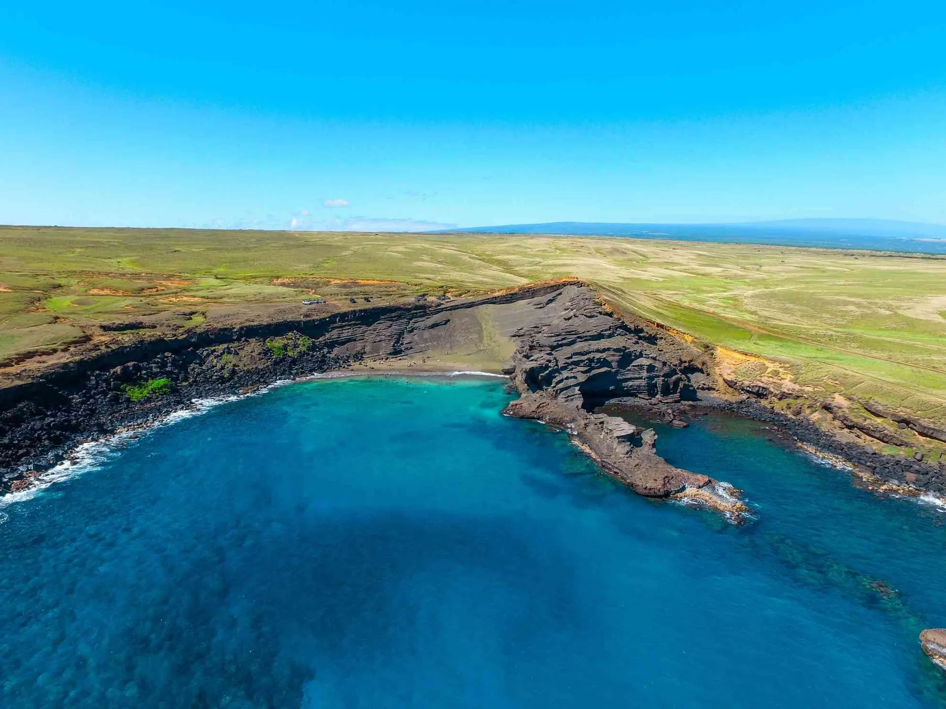 The olive-green sand of Papakolea beach inside its eroded cinder cone on the Big Island.