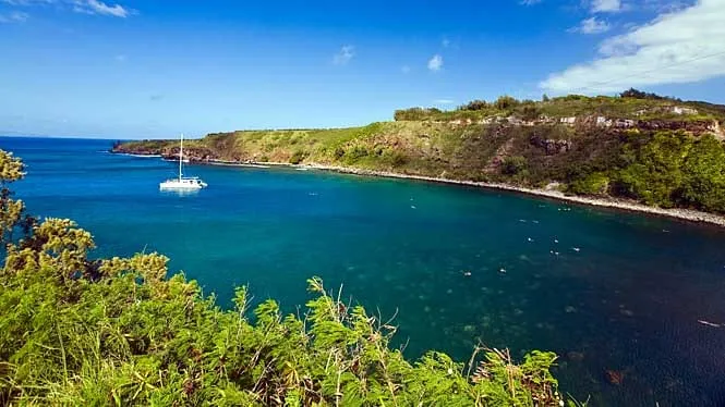 A boat anchored in the clear water of Honolua Bay, West Maui.