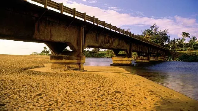 The Wailua River bridge arching over the river mouth at Wailua Beach.