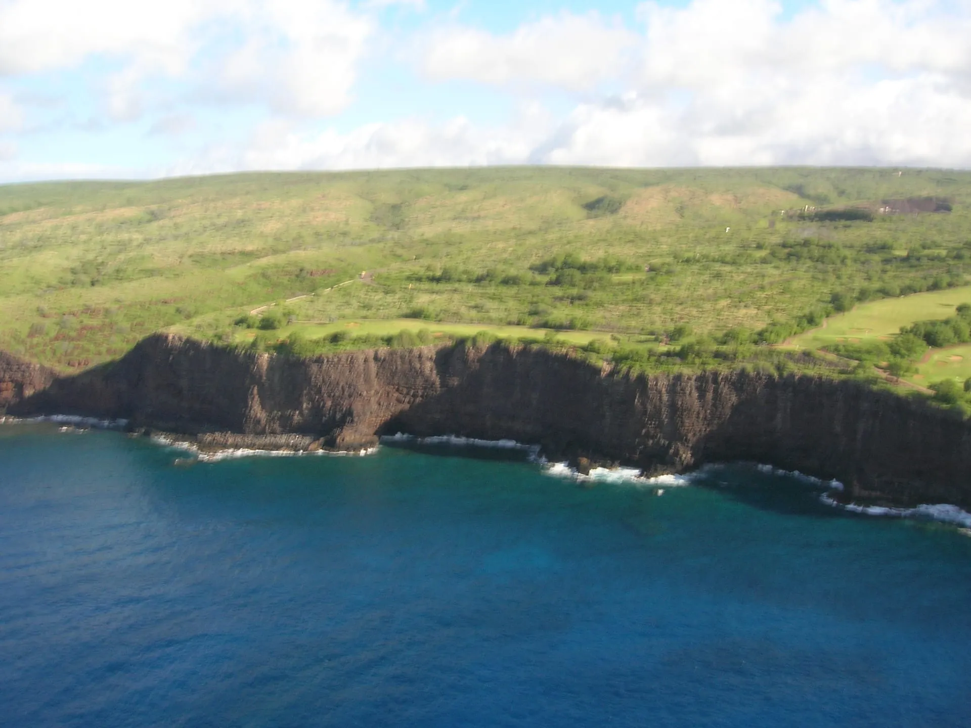 The sea cliffs and cove of Huawai Bay on Lanai’s south coast, seen from above.
