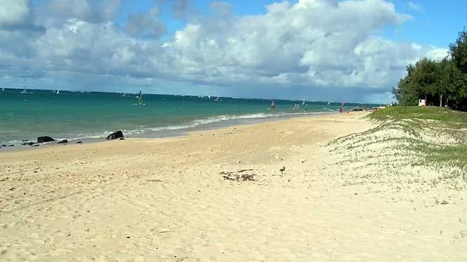 The long, wide sand of Kanaha Beach Park, Kahului, with the trade-wind surf beyond.
