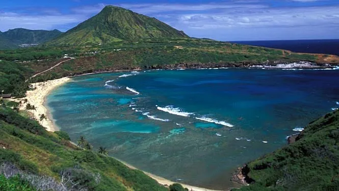 Hanauma Bay’s reef and curved beach seen from the rim of the crater, with Koko Head beyond.