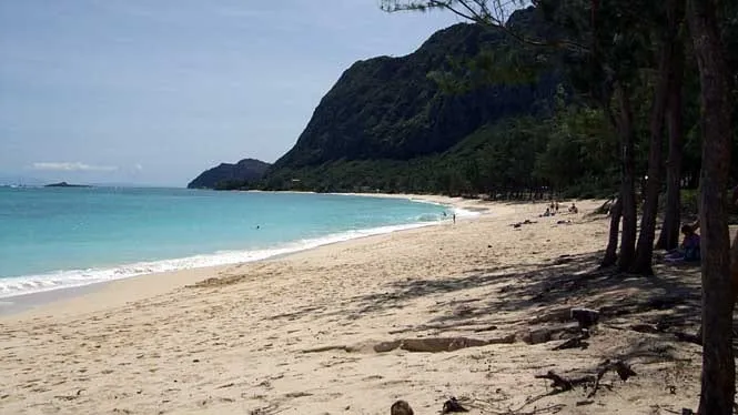The long white sand of Waimanalo Beach Park with the Koolau cliffs rising behind.