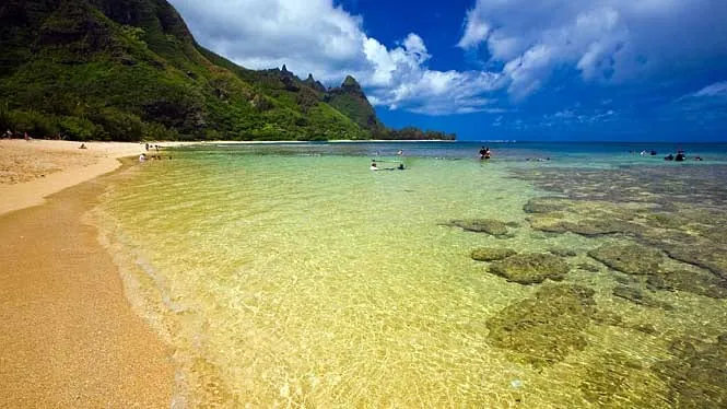 The turquoise reef shallows and sand of Tunnels Beach at Haena, Kauai.